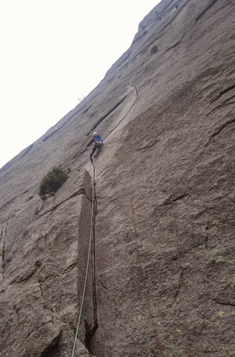 person in blue shirt climbing on brown mountain
